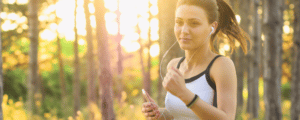 Woman running happy and healthy through the forest